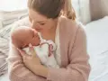 Delikatna pozycja do odbijania noworodka w ramionach mamy, która tuli go z miłością.