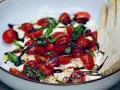 Frische Insalata Caprese mit saftigen Tomaten, cremigem Mozzarella und Basilikum, beträufelt mit Balsamico.