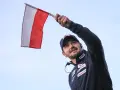 Radosny kibic z polską flagą na skoki narciarskie mistrzostwa świata juniorów.
