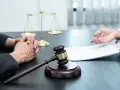 Sądowy młotek i waga sprawiedliwości symbolizują prawo. Rozmowa o dziedziczeniu i zachowku w kancelarii prawnej.