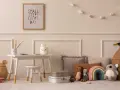 Ein Kinderzimmer mit einem kleinen Schreibtisch, Spielzeug und einem Bild mit der Aufschrift "Small steps every day". Eine beige Mom würde sich hier wohlfühlen.