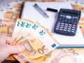 Ein Händchen hält 50-Euro-Scheine. Daneben liegen ein Taschenrechner und ein Notizbuch. Die Frage: bis wann muss man Unterhalt zahlen?