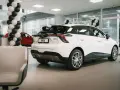 Biały samochód MG4 Electric prezentowany w salonie, ozdobionym czarno-białymi balonami.