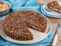 Sbriciolata ricotta e cioccolato con croccante copertura di nocciole. Una fetta invitante attende su un piattino.