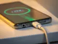 Smartfon podłączony do ładowarki, na ekranie widać wskaźnik baterii. Tak wygląda ładowanie telefonu.