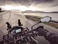 Jazda motocyklem w deszczu w kierunku Nordkapp. Pochmurne niebo i mokra droga nie zniechęcają do podróży.