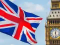 Flaga Wielkiej Brytanii powiewa przed Big Benem. Zastanawiasz się, ile kosztuje eta do UK?