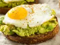 Tostada integral con aguacate machacado y huevo frito, un delicioso desayuno keto.