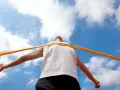 Atleta taglia il traguardo, la fatica della maratona km è ripagata. Cielo azzurro e nuvole bianche.