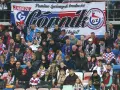 Tłum kibiców Górnika Zabrze, w szalikach i barwach klubowych, wspiera drużynę.