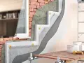 Dettaglio costruttivo che illustra la differenza tra coibentazione e cappotto termico: strati isolanti applicati su una parete in mattoni con finitura esterna.