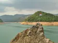 Serbska flaga na skale nad jeziorem. Krajobraz zachęca do podróży, a pytanie "czy Serbia jest bezpieczna dla turystów" wydaje się nie mieć znaczenia w obliczu tego spokoju.