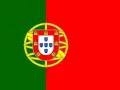 Flaga Portugalii z zielono-czerwonym podziałem i tarczą herbową z zamkami i tarczkami z pięcioma niebieskimi tarczkami.