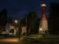 Nocna panorama latarni morskiej Rozewie z oświetloną wieżą i budynkami.