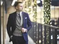 Elegancki mężczyzna w granatowym garniturze i kamizelce, gotowy na wieczorne wyjście. Jego strój koktajlowy podkreśla jego styl.