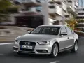 Srebrne Audi A4 B8 w ruchu miejskim, znane z typowych usterek, pędzi ulicą.