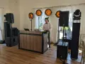 Młody DJ przy konsoli, otoczony sprzętem nagłośnieniowym i oświetleniem. Unikaj błędów w wyborze oprawy muzycznej – DJ czy zespół?