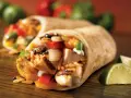 Pyszna tortilla z kurczakiem na ciepło, ryżem, warzywami i serem. Idealna na szybki posiłek.