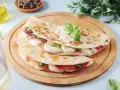 Piadina come farcirla: prosciutto, mozzarella filante e basilico fresco, un'idea gustosa e veloce.