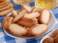 Un piatto pieno di croccanti lingue di gatto, perfette per accompagnare un tè o un caffè.