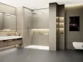 Une douche à l'italienne moderne, spacieuse et épurée, avec une paroi en verre, un pommeau de douche carré et un receveur blanc.