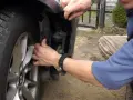 Naprawa awarii PDC BMW. Mężczyzna demontuje fragment nadkola, by dostać się do czujników parkowania.