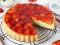 Ein saftiger tortenboden mit erdbeeren, bedeckt mit glänzendem Tortenguss. Ein Stück wurde bereits entnommen, um die köstliche Füllung zu zeigen.