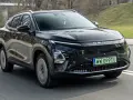 Czarny OMODA elektryk w ruchu drogowym. Nowoczesny design z charakterystycznym pasem świateł LED i logo marki.