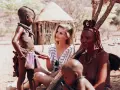 Ludzie Himba w Namibii: młoda kobieta rozmawia z dzieckiem i starszą kobietą w tradycyjnych strojach.