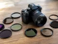 Appareil photo noir entouré de plusieurs filtres pour la photo, dont un filtre UV.