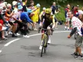 Jonas Vingegaard, with his impressive VO2 max, powers through a crowd of cheering fans in a cycling race.