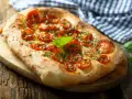 Pyszna focaccia z pomidorkami koktajlowymi i bazylią. Idealna jako dodatek do dań lub samodzielna przekąska. Z czym jeść focaccię? Z wszystkim, co lubisz!