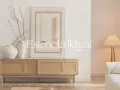 Un mobile in legno con ante in rattan, vasi in ceramica e un quadro astratto, in un ambiente che evoca il wabi sabi design.
