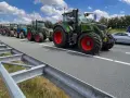 Una fila di trattori attraversa un'autostrada, un'immagine che ricorda che sulle autostrade e strade extraurbane principali è vietata la circolazione di macchine agricole.