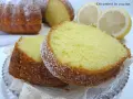 Fette di ciambellone al limone spolverate di zucchero a velo, con fette di limone sullo sfondo.