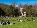 Pratolino: cosa vedere? La statua del Colosso dell'Appennino domina un prato verde affollato di persone che si godono il sole.