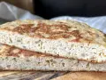 Dwa kawałki puszystego chleba keto z widocznymi ziarnami na drewnianej desce. Idealny na niskowęglowodanowe śniadanie.
