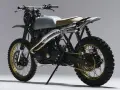 Stylowy motor scrambler z matowym, srebrnym bakiem, podwójnym wydechem i terenowymi oponami. Gotowy na przygodę!