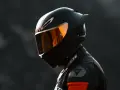 Casco nero lucido con visiera arancione riflettente, pronto per un giro in moto.