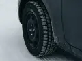 Ruota di un'auto con pneumatico invernale coperto di brina, pronto per affrontare la neve. La scheda pneumatici è fondamentale per la sicurezza.