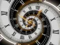Złoty zegar z rzymskimi cyframi, tworzący spiralę nieskończoności. Symbolizuje 5 rok numerologiczny, czas zmian i rozwoju.