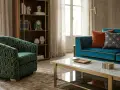 Poltrona verde con motivo geometrico dorato, che ricorda come si fa il velluto, accanto a un divano blu e un tavolino di marmo.