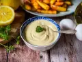 Cremige Mayonnaise, perfekt für Ihr nächstes mayonnaise rezept. Dazu passen goldbraune Pommes, frische Petersilie, Zitrone und Eier.