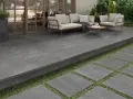 Terraza moderna con suelo de baldosas grises, ideal para saber como poner baldosas en suelo de tierra. Sofá y sillones invitan al descanso.