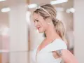 Elegancki kucyk ślubny z perłową opaską i kolczykami. Panna młoda w białej sukni z dekoltem.