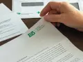 Dłoń trzyma dokument ZUS. Temat: koniec umowy a L4.