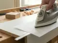 Utilisation d'un fer à repasser pour enlever colle thermocollant sur tissu, une technique de bricolage pour une finition parfaite.