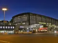 Der Bahnhof Zoo in Berlin bei Nacht. Die beleuchteten Terrassen am Zoo erstrahlen im Dunkeln.