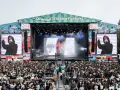 Tłum ludzi na Orange Warsaw Festival 2026, scena z artystą na ekranie i dymem.