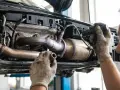 Mechanik naprawia katalizator, który może być przyczyną błędu DTC P0420.